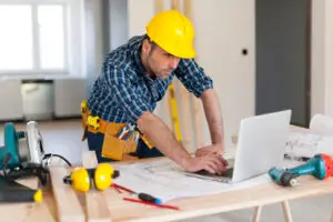 a contractor working on a computer with tools around him